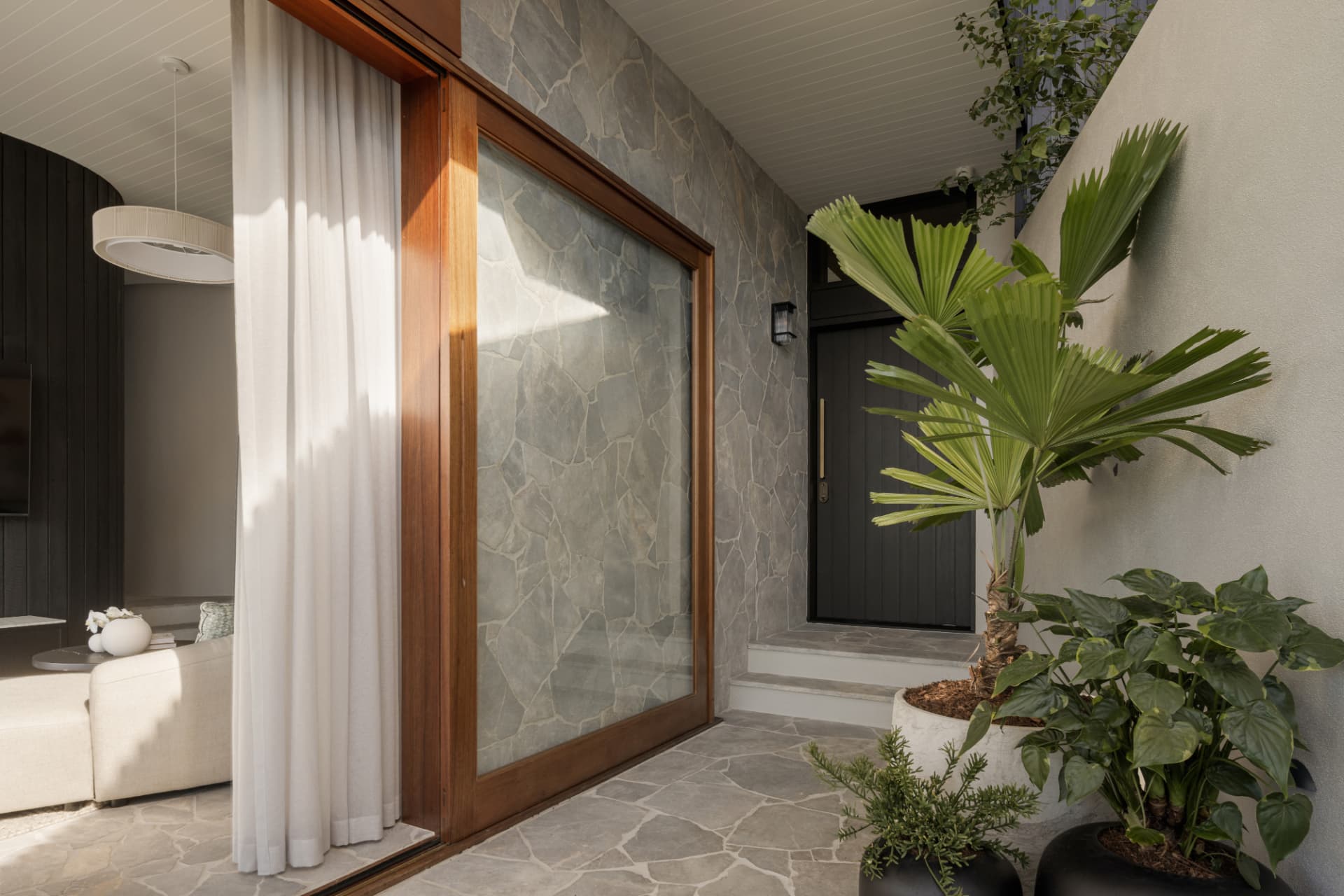 Stone-clad entry portico with tropical planting