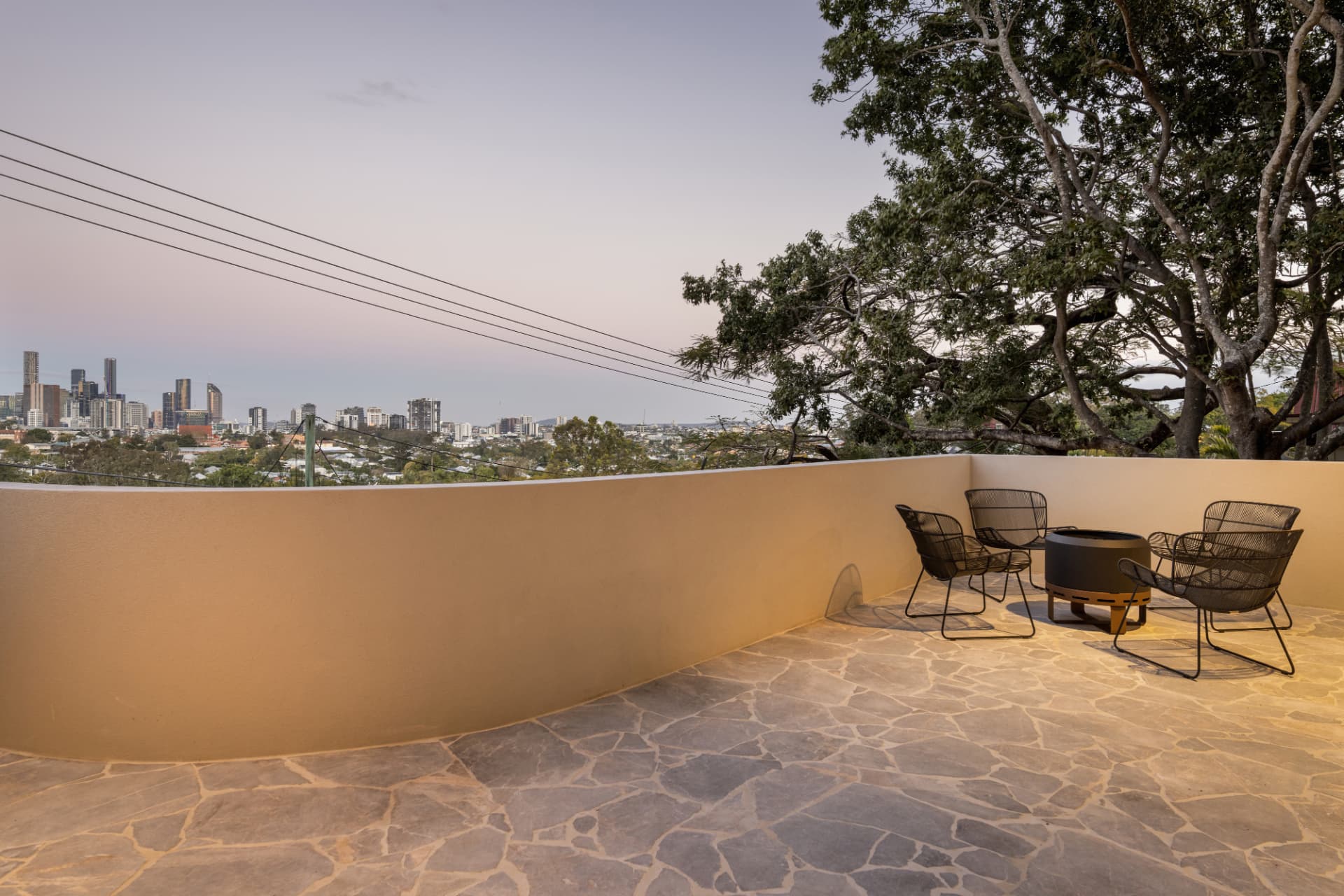 Curved rendered terrace with fire pit under the poinciana